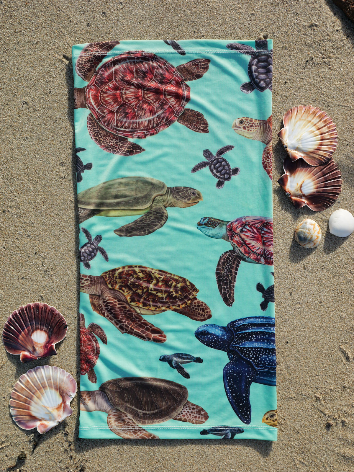 Big turtles green UV gaiter buff design shown laid out full length close up in great detail shells sand background made from recycled polyester-spandex ocean illustration by Diver Mon Art