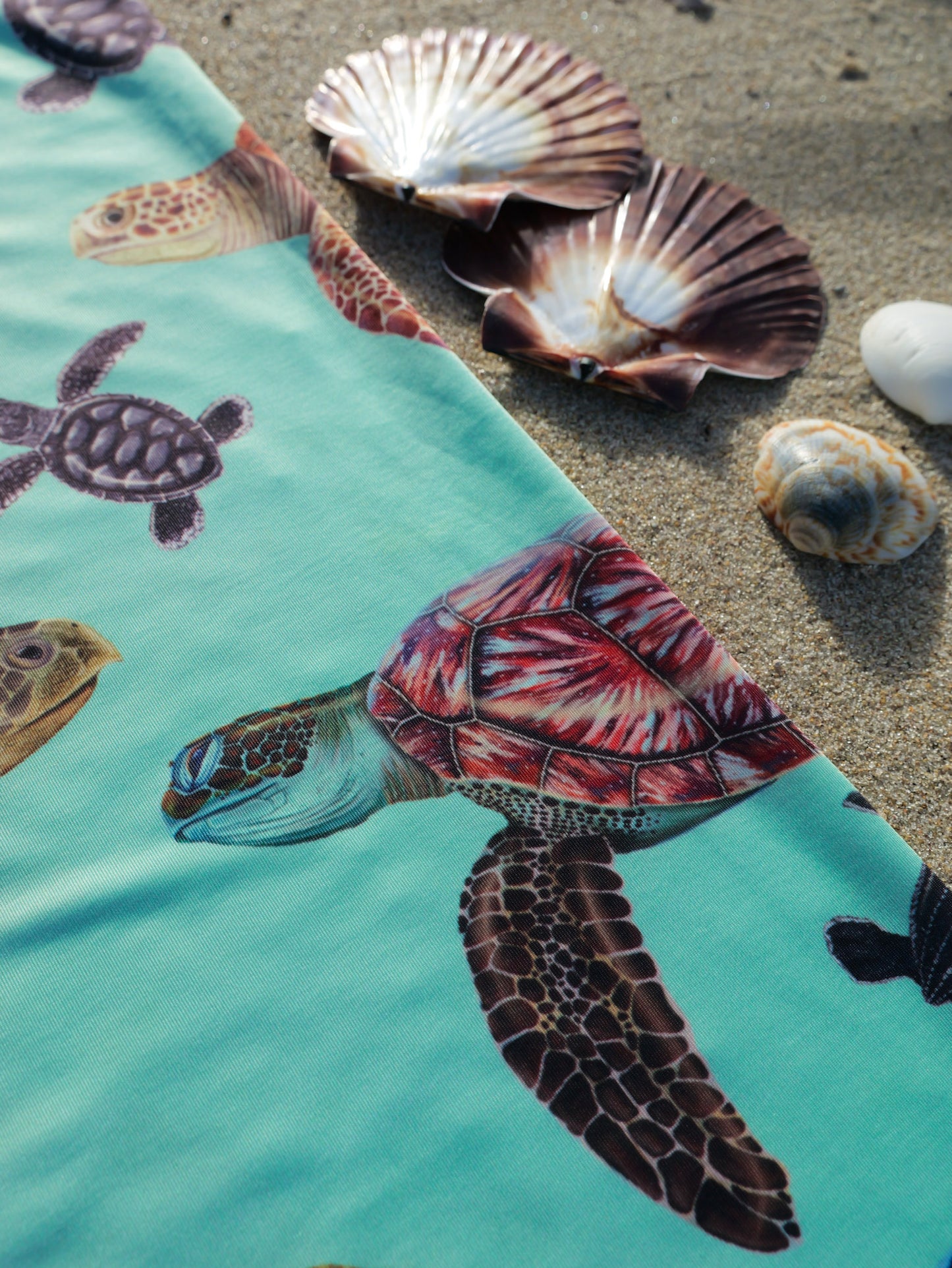 Big turtles green UV gaiter buff design shown laid out close up in great detail shells sand background made from recycled polyester-spandex ocean illustration by Diver Mon Art 