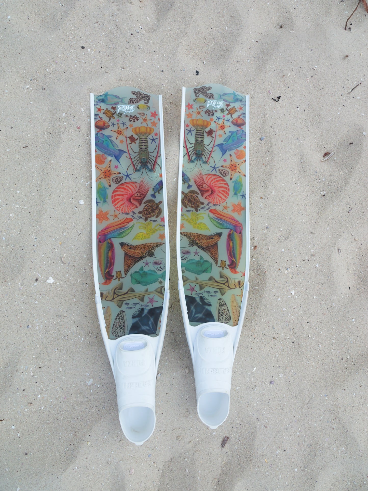 Colourful freediving fins with marine illustrations by divermon on a sandy background