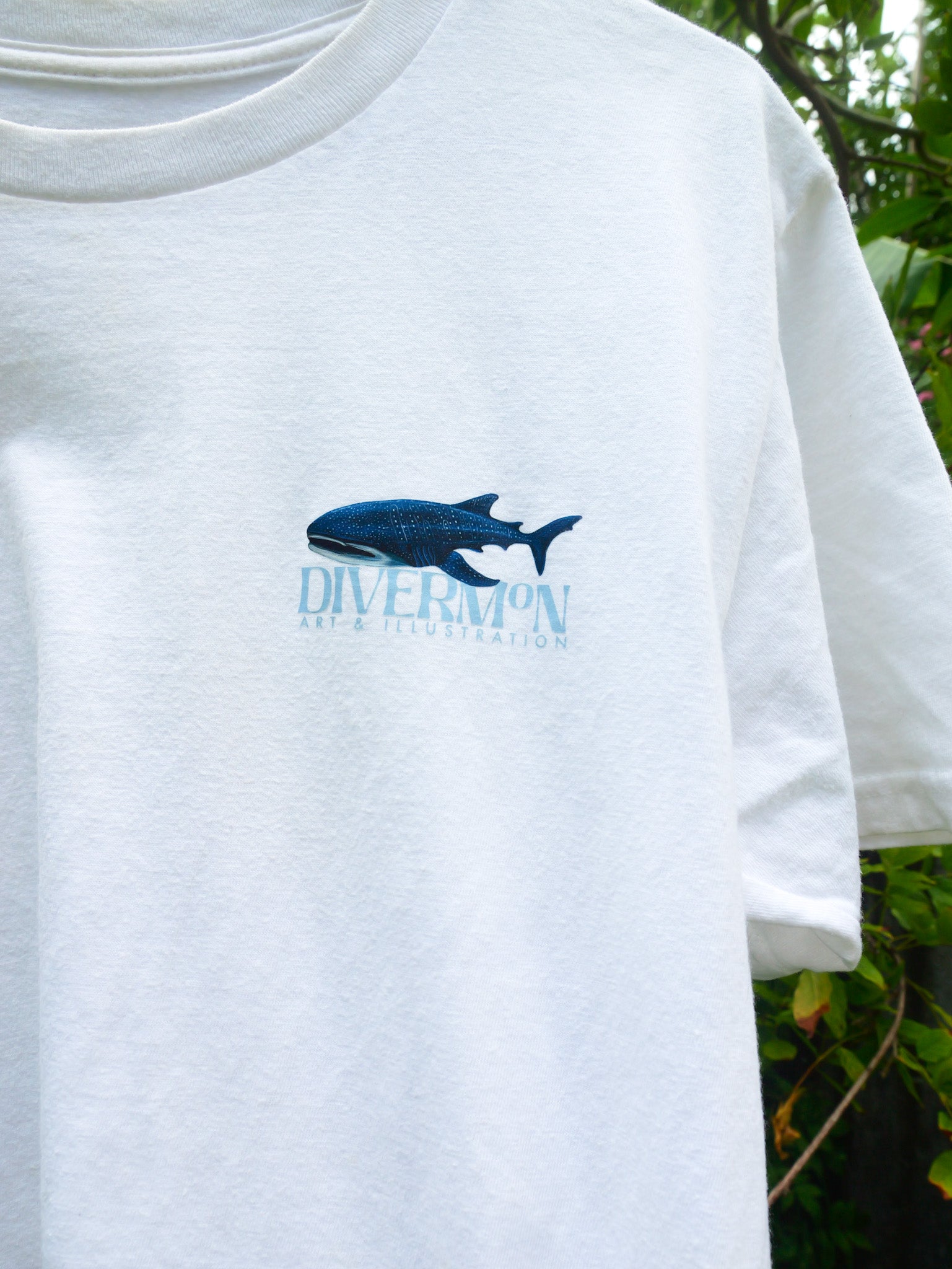 White t-shirt with a blue whale shark logo and 'Diver Mon Art' text on a white background