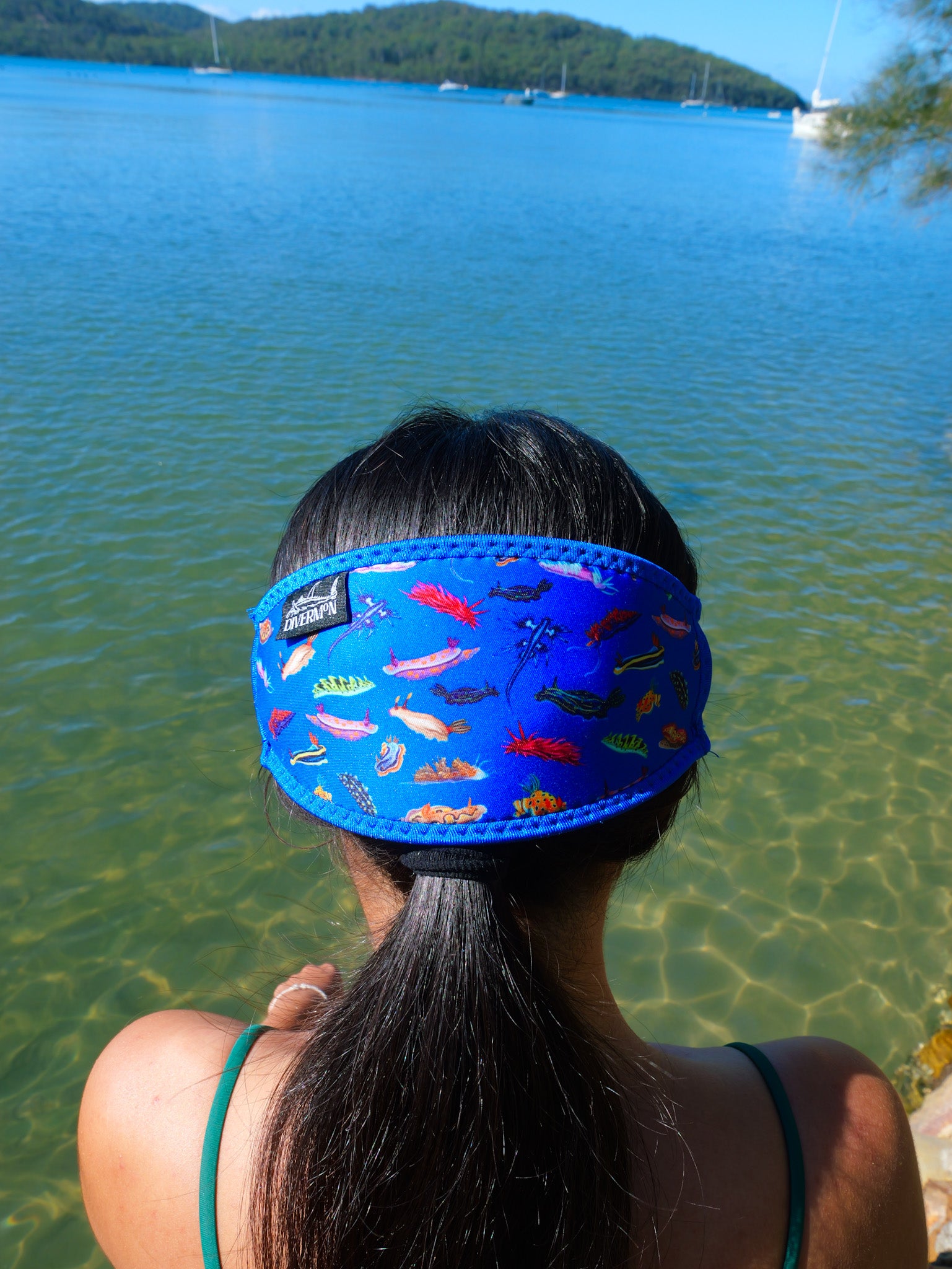 Dark haired woman seen from behind in clear blue water nudibranch dark blue background neoprene mask strap tamer close up ocean illustration by Diver Mon Art 