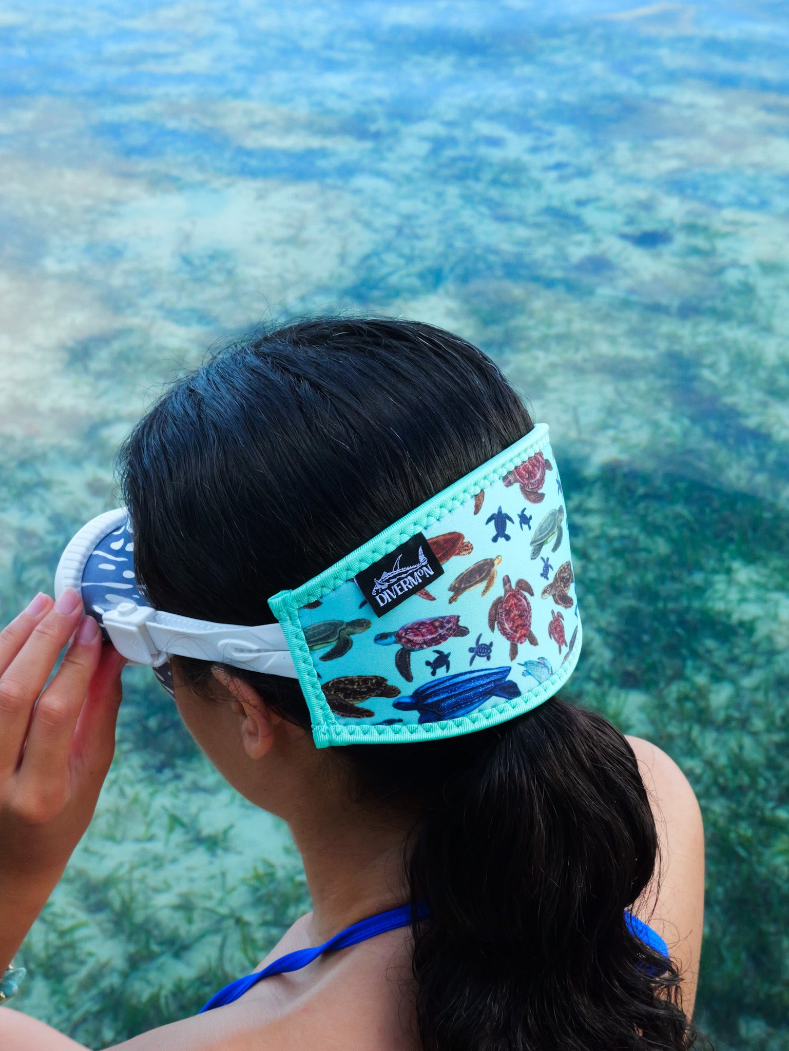 Dark haired woman seen from side view in clear blue water Sea turtle design with a light green background neoprene mask strap tamer ocean illustration by Diver Mon Art dive hair accessories
