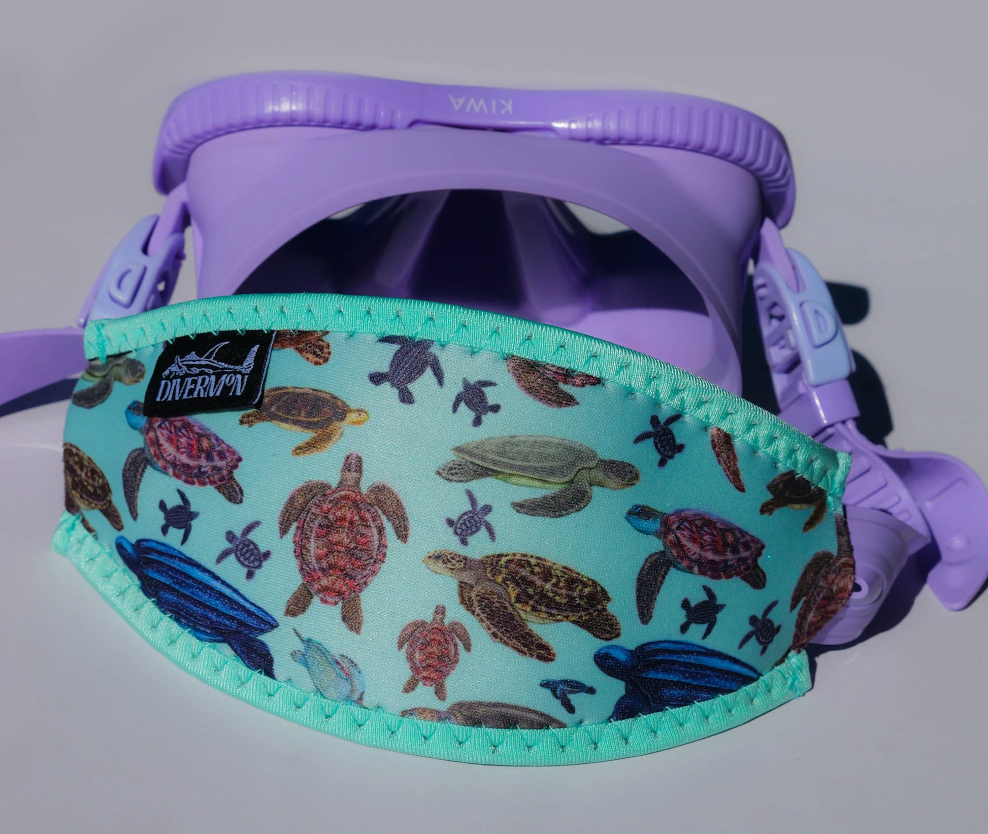 Turtle green neoprene mask tamer by Diver Mon Art shown with fitted to purple mask 
