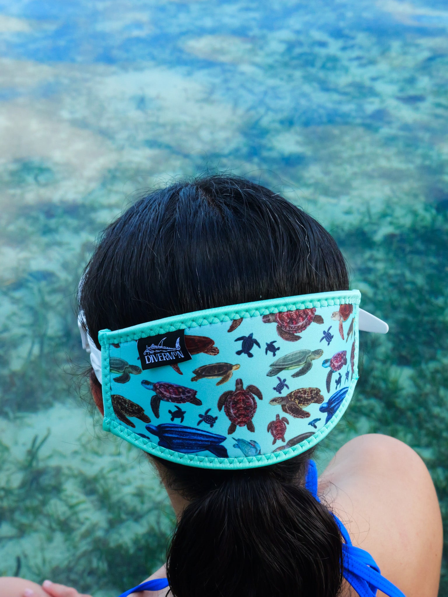Dark haired woman seen close up from behind in clear blue water turtles design with green background neoprene mask strap tamer detailed ocean illustration by Diver Mon Art 