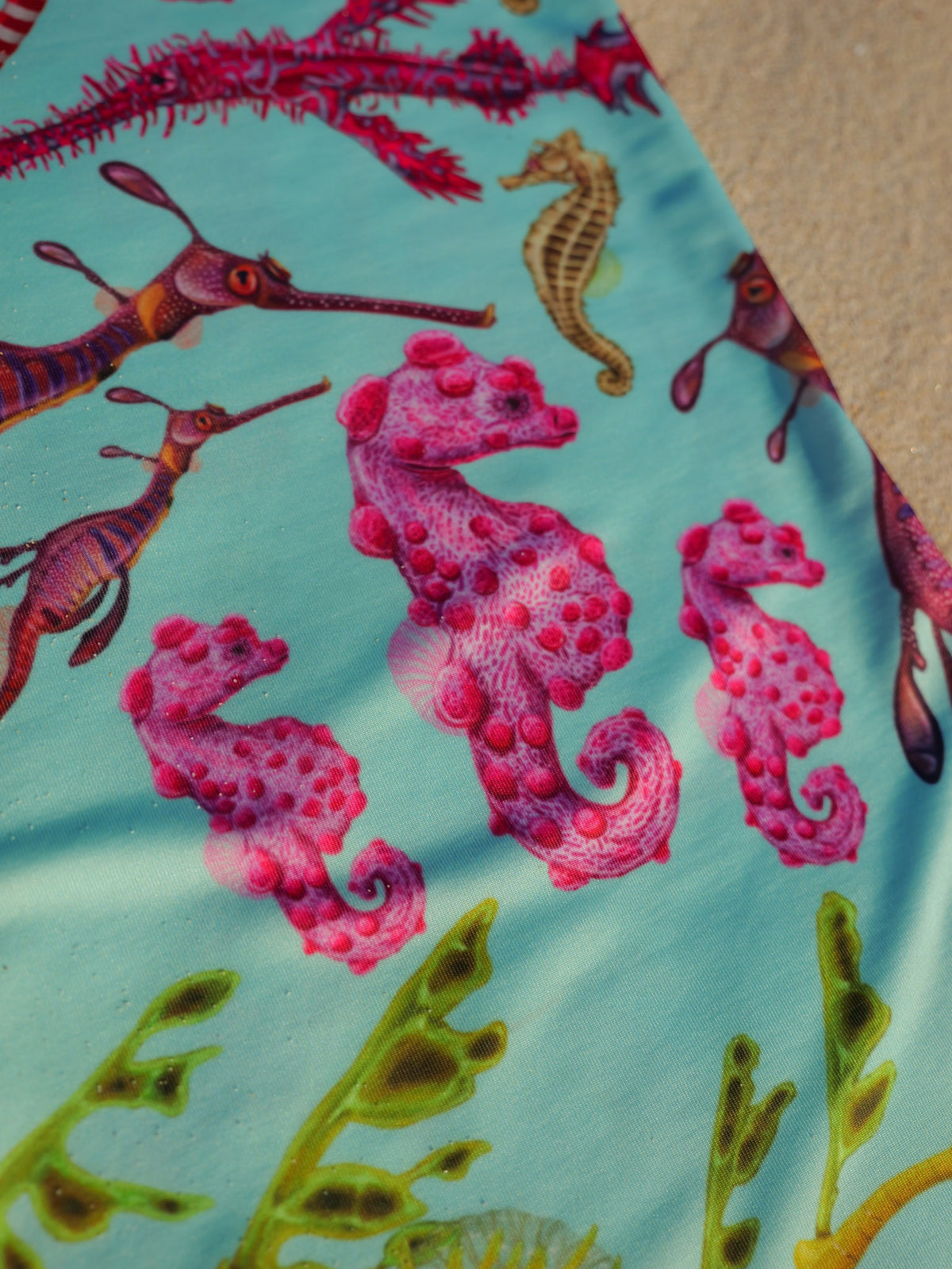 Seahorse green UV gaiter buff design shown close up in great detail sand background made from recycled polyester-spandex ocean illustration by Diver Mon Art