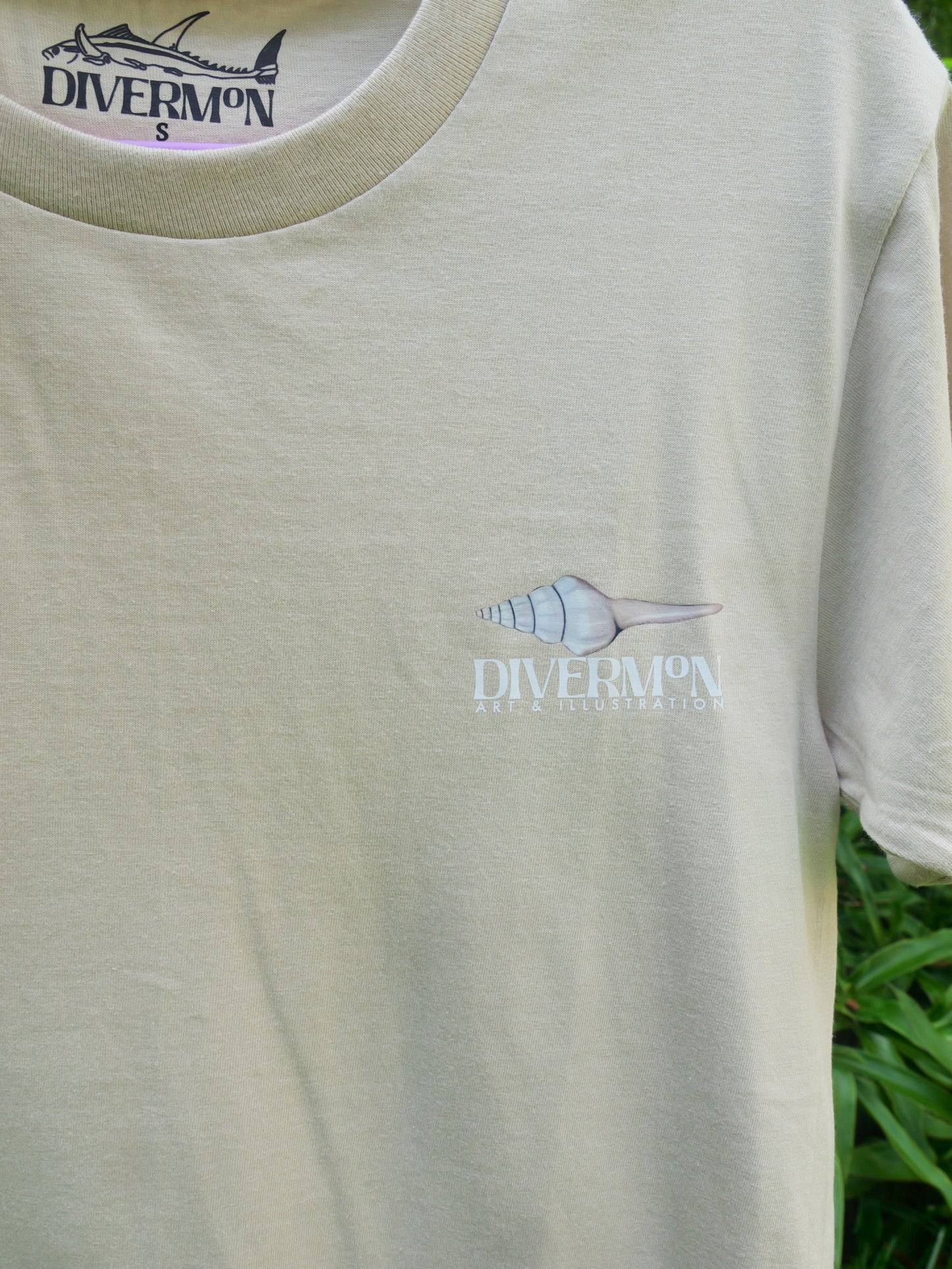 Seashell t shirt featuring ocean shell artwork by Diver Mon Art marine life illustration for beach lovers front logo