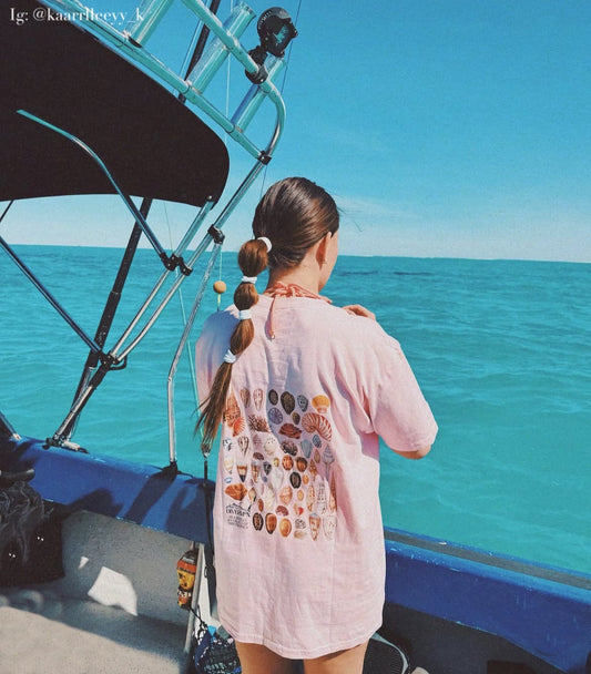 Pink seashell t shirt featuring ocean shell artwork by Diver Mon Art marine life illustration for beach and coastal style