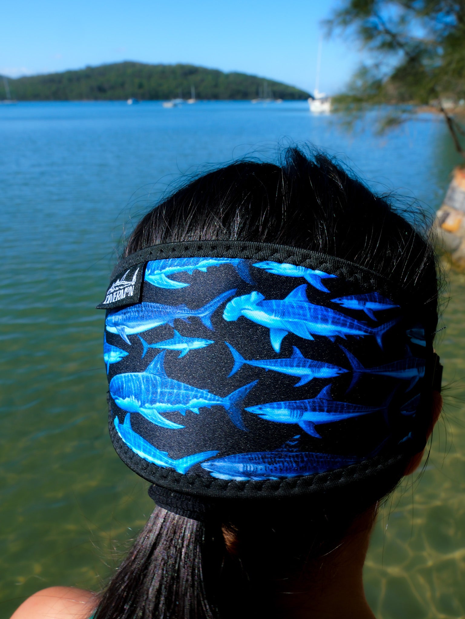 Dark haired woman shown from behind in blue clear water close up shark black design neoprene mask strap tamer ocean illustration by Diver Mon Art 