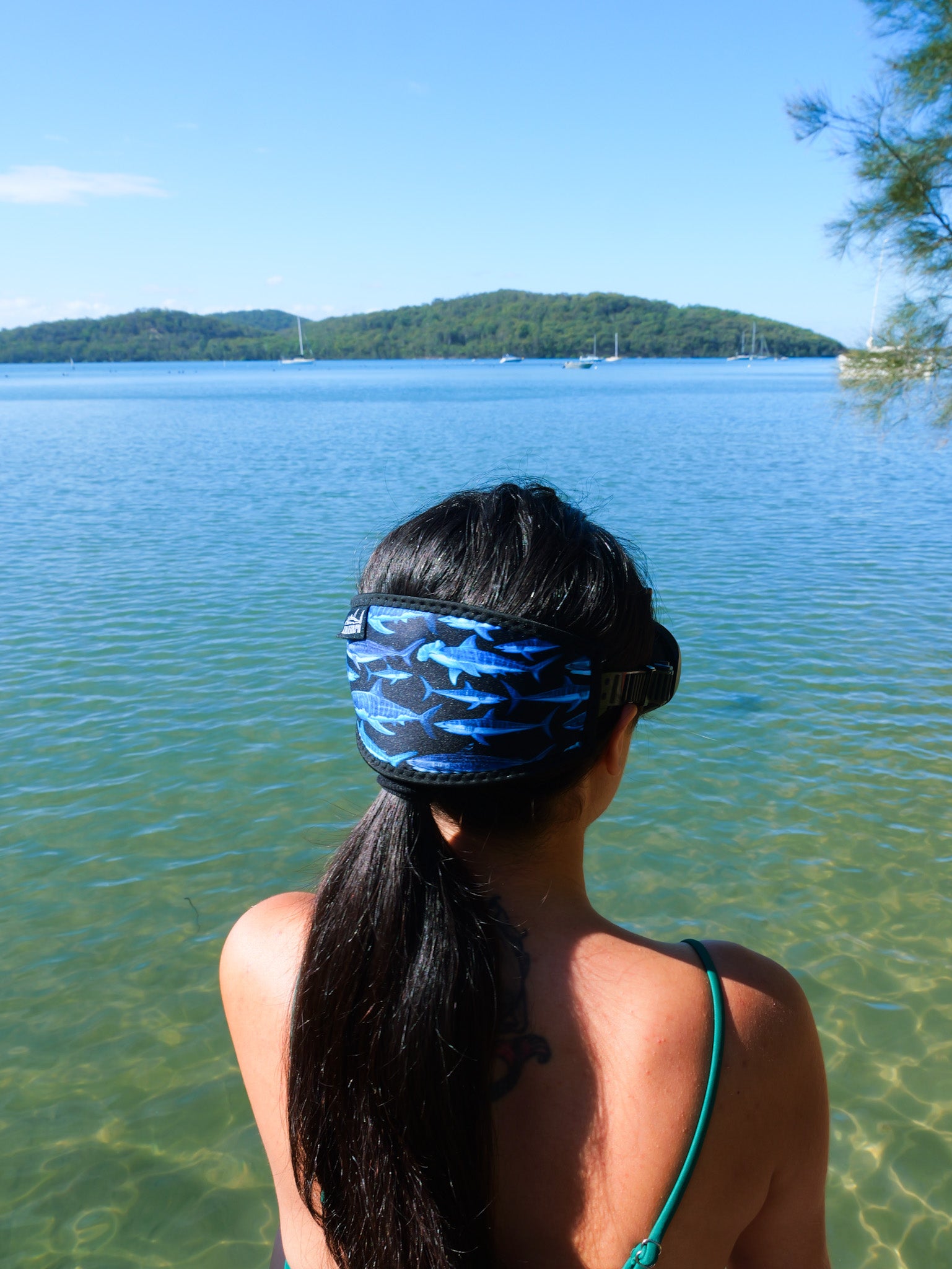 Dark haired woman shown from behind side view in clear water close up shark black design neoprene mask strap tamer ocean illustration by Diver Mon Art  