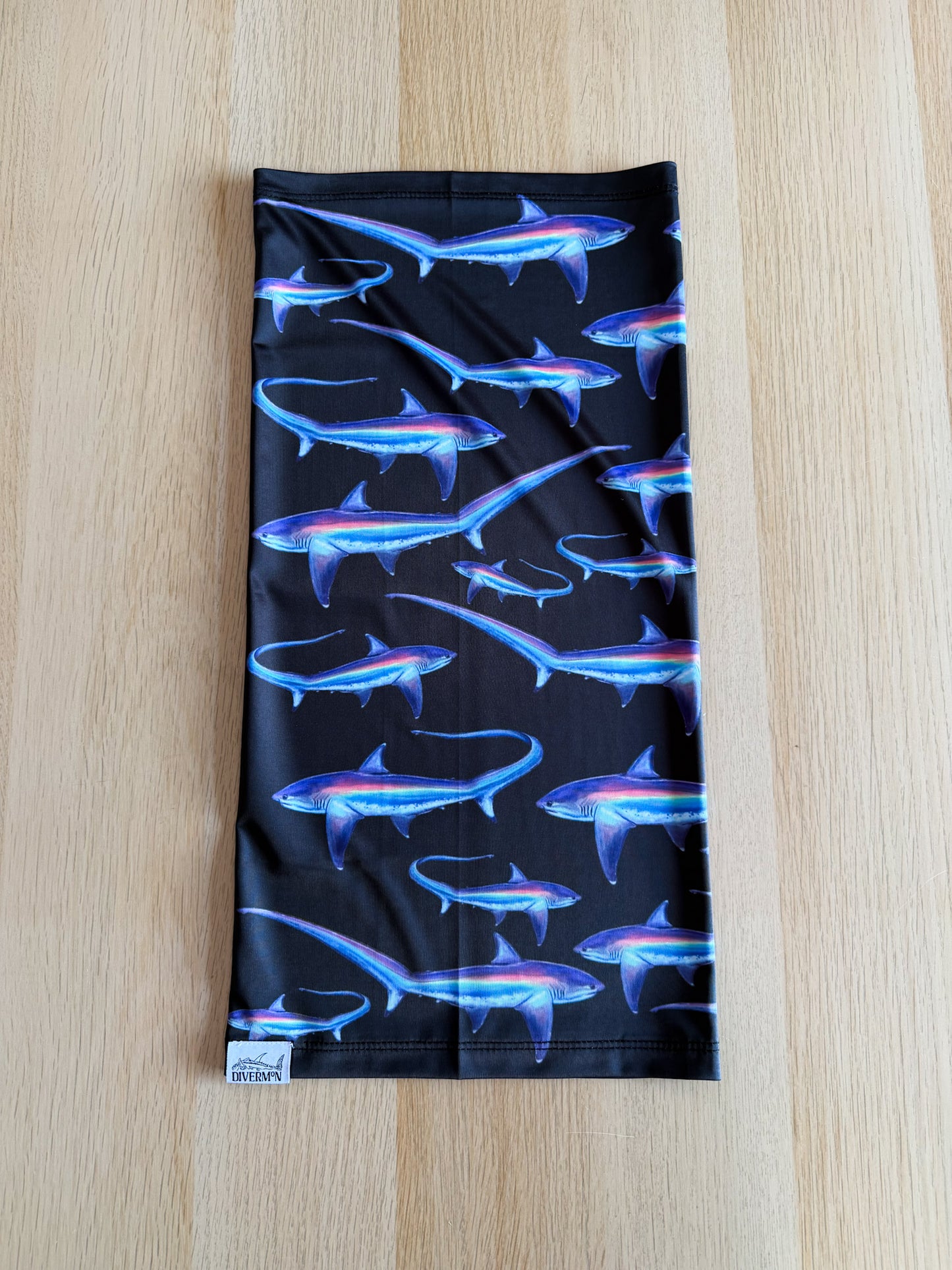 Limited addition thresher black UV gaiter buff design shown laid out on wooded background made from recycled polyester-spandex ocean illustration by Diver Mon Art 