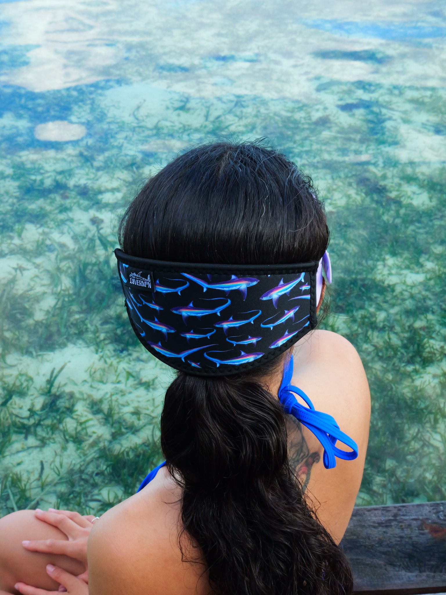 Dark haired woman seen from behind in clear blue water thresher design with black background neoprene mask strap tamer ocean illustration by Diver Mon Art 