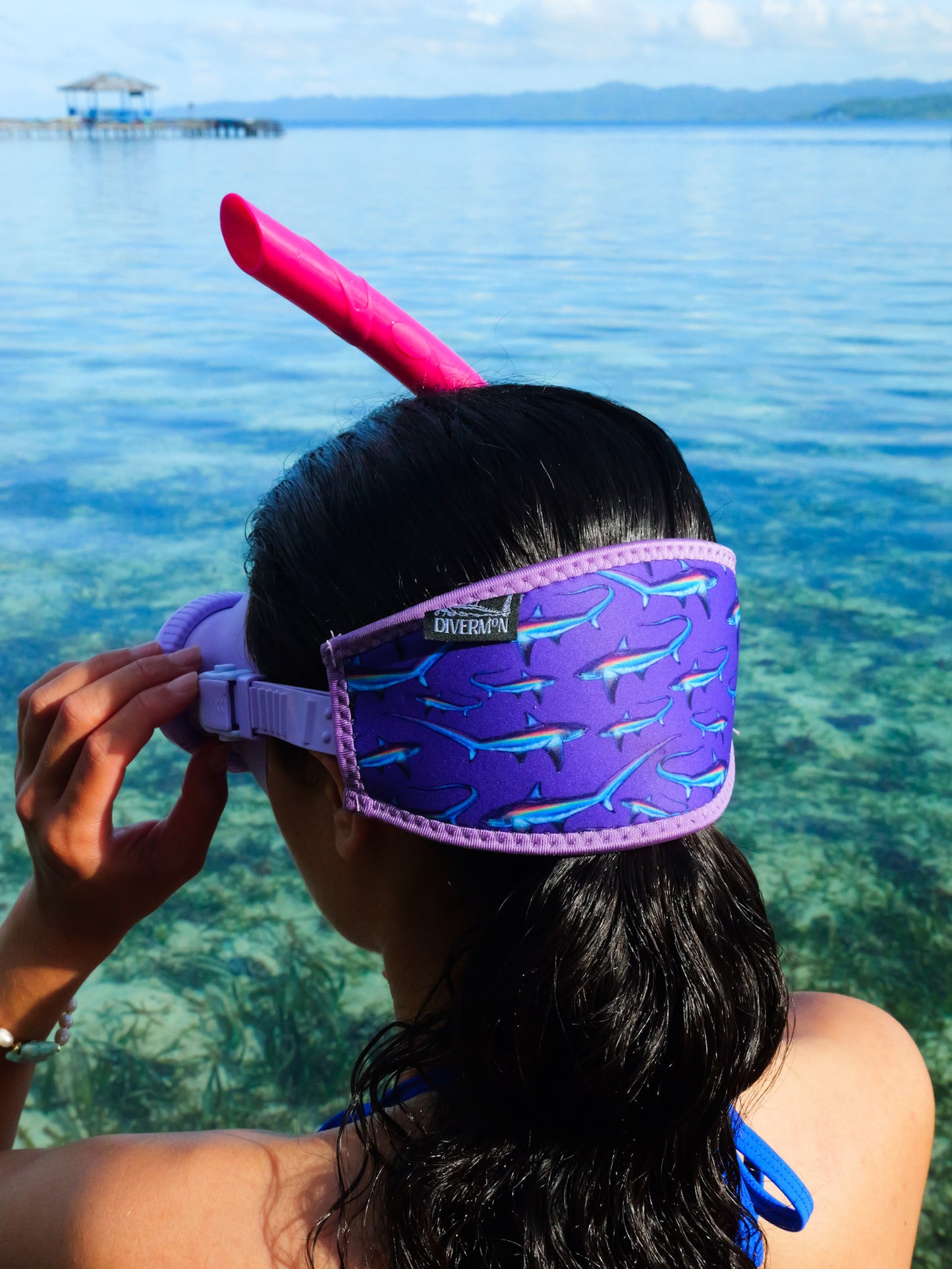 Dark haired woman shown from behind in blue clear water close up thresher purple design neoprene mask strap tamer ocean illustration by Diver Mon Art