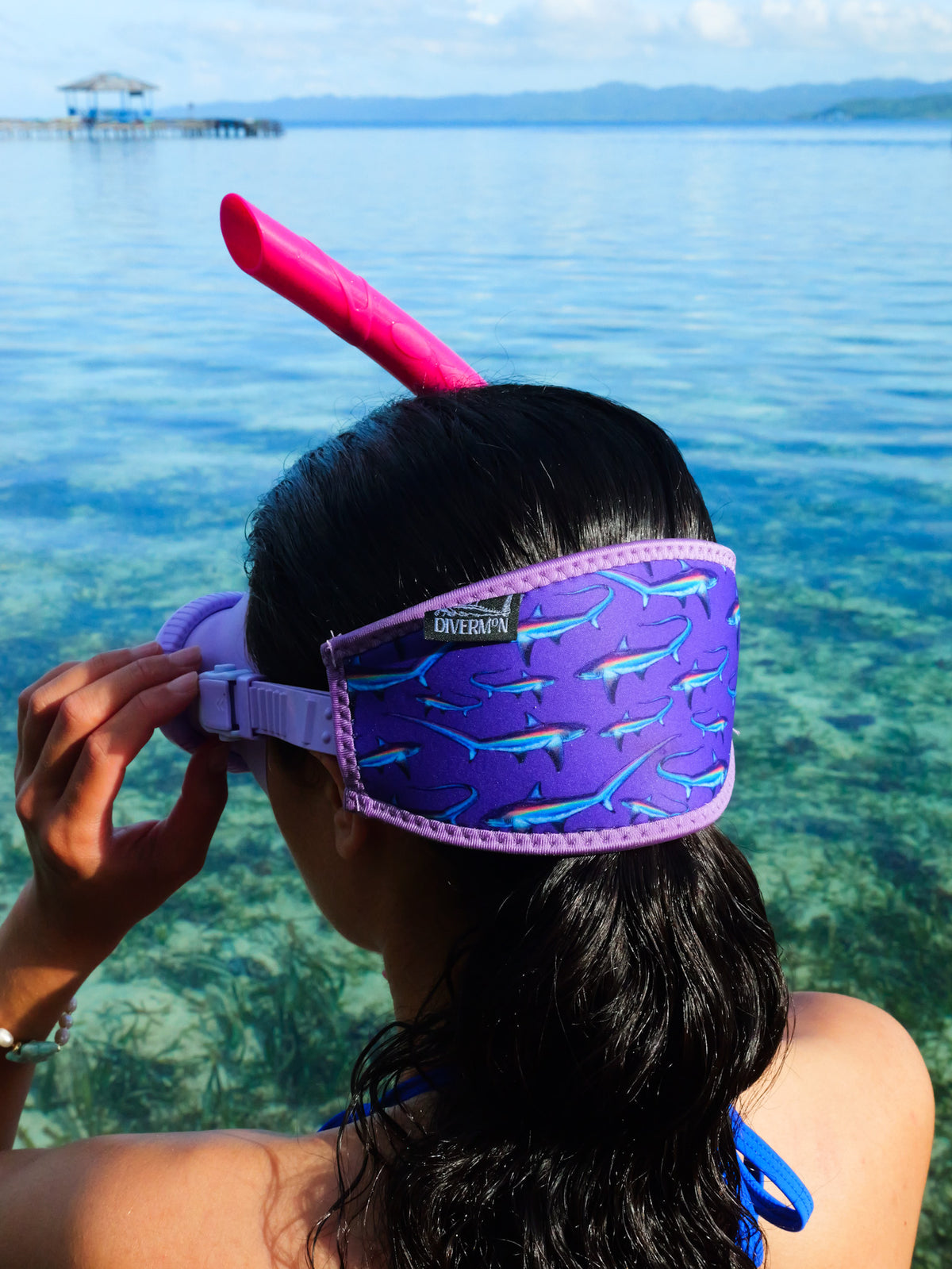 Dark haired woman shown from behind in blue clear water close up thresher purple design neoprene mask strap tamer ocean illustration by Diver Mon Art